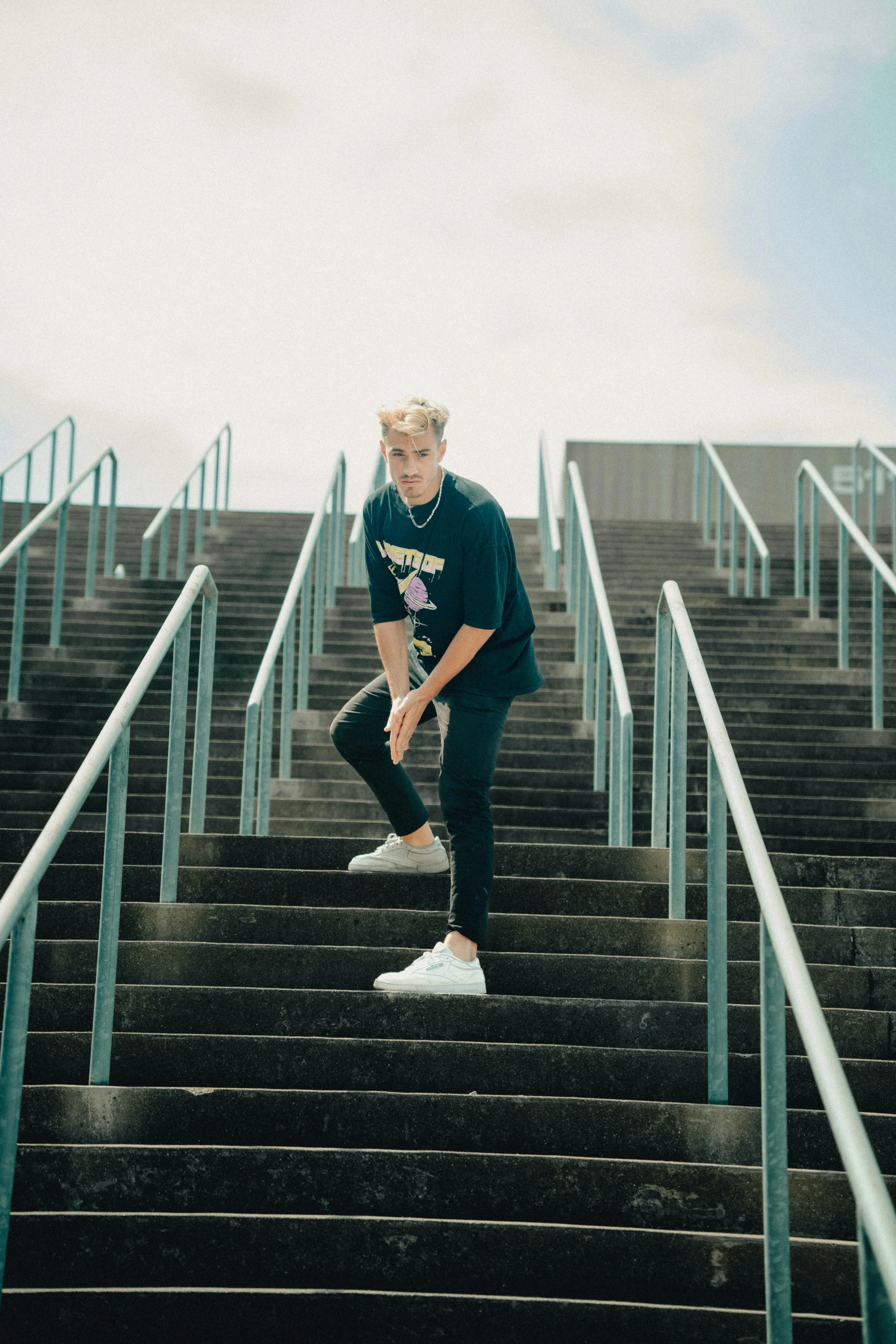 a male in a black shirt is standing on stairs