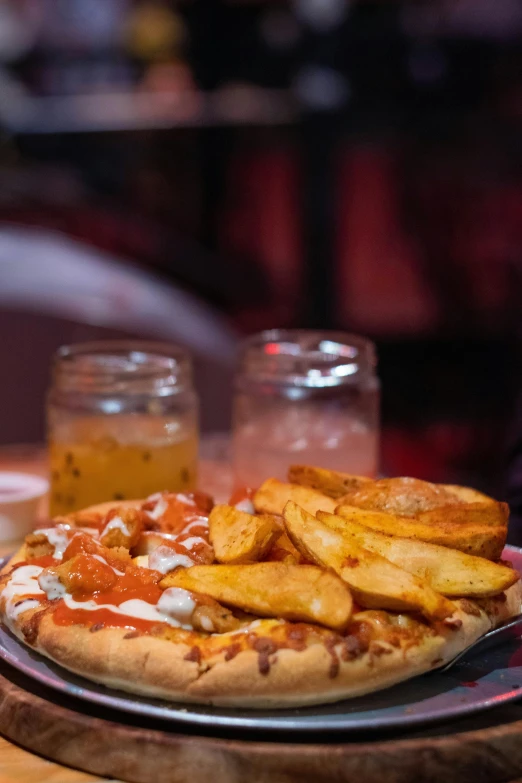 a pizza is next to some french fries on a table