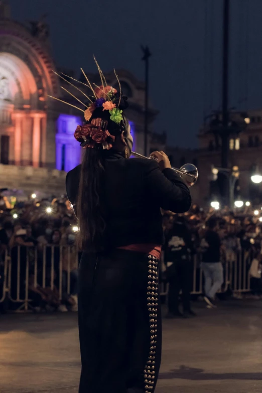 an asian woman in costume with flowers on her head at night