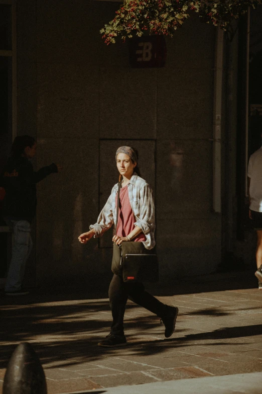 a woman is walking in the street carrying luggage