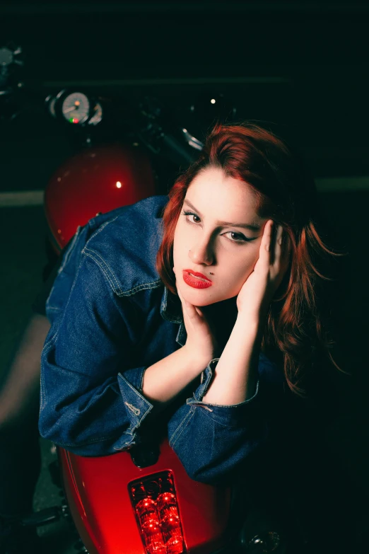 a woman in a jean shirt sits on a motorcycle