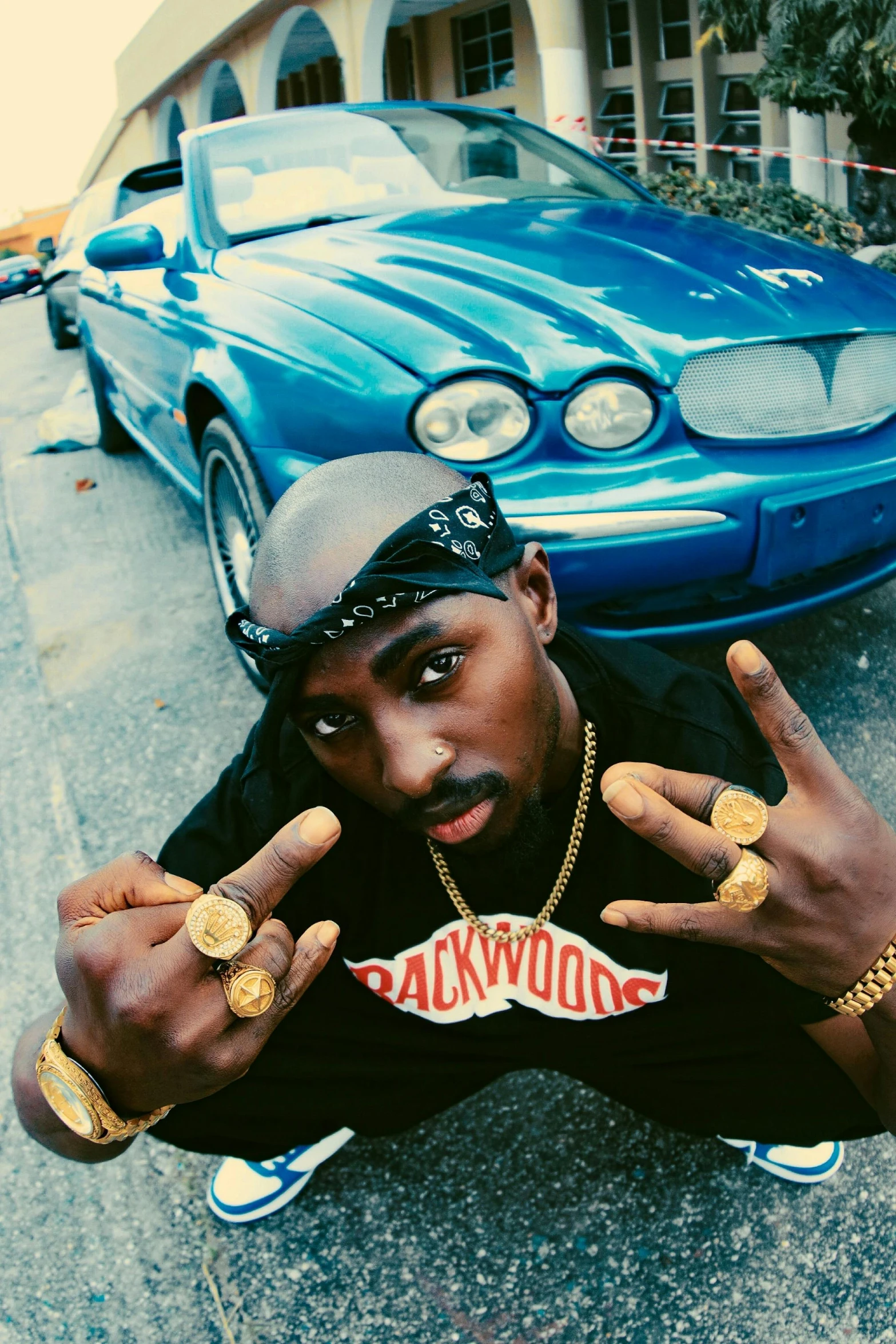 a man sitting in front of a car pointing two fingers