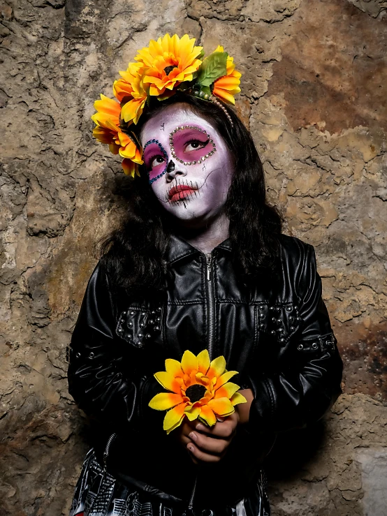 a woman with makeup on is holding some yellow flowers