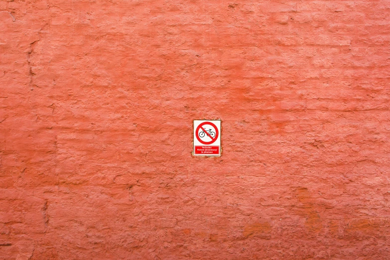 a red wall with a sign that is in the middle of it