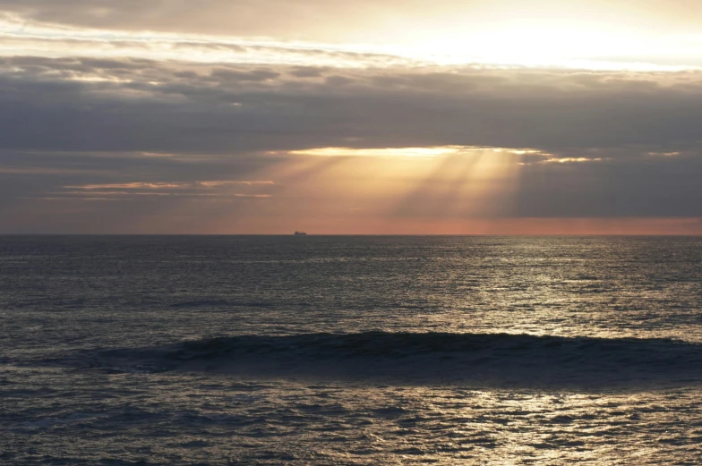 the sun beams shine brightly over the horizon as a boat cruises through the open water