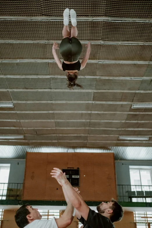 two boys are in the gym with a man on his back