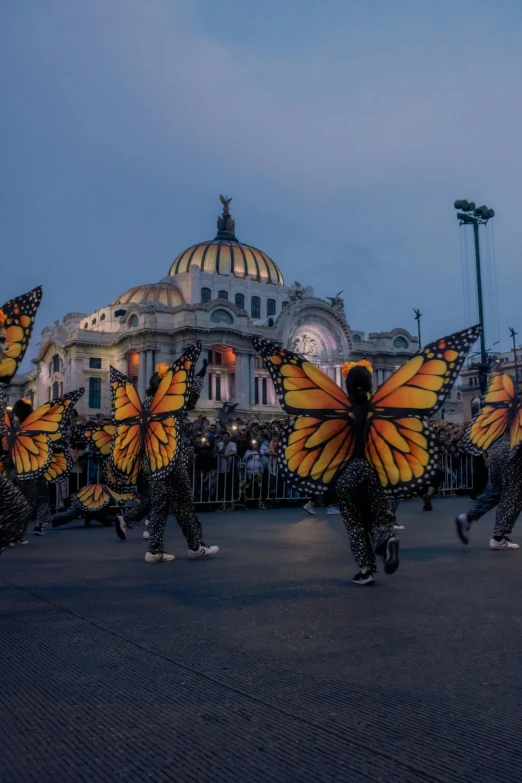 some people with yellow wings dance in a circle