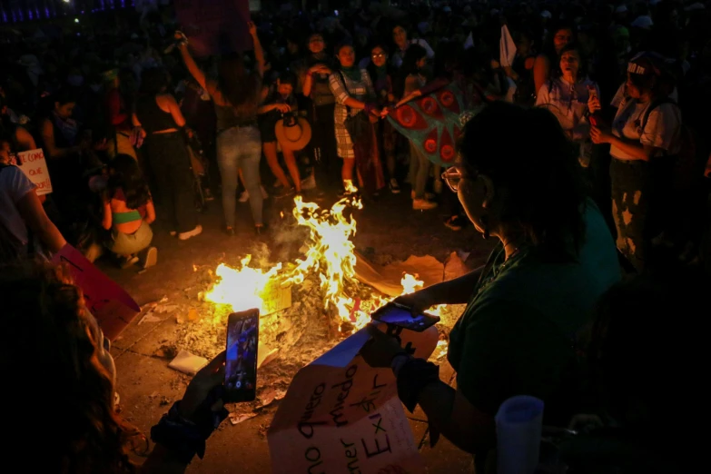 a large crowd is gathered around a fire