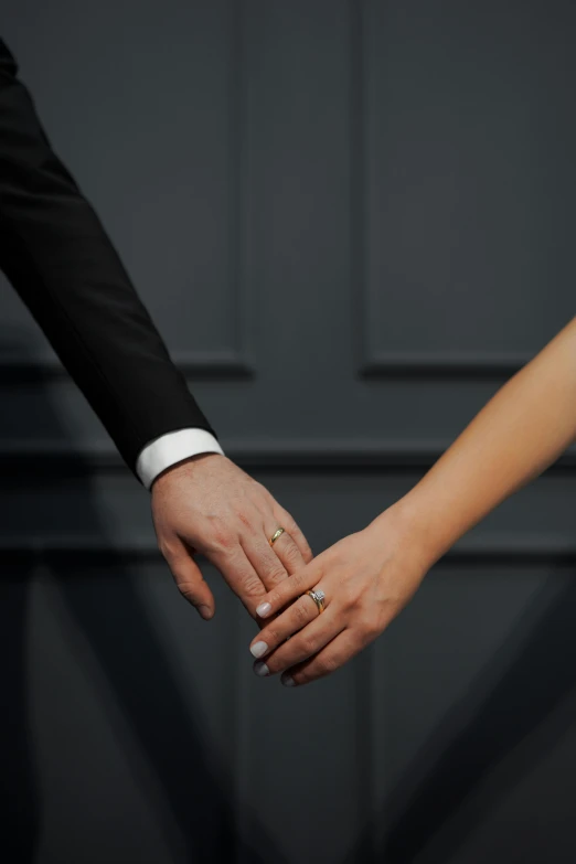 an engaged couple holds their hands