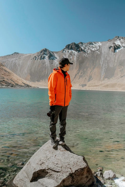 the man is standing on a large rock