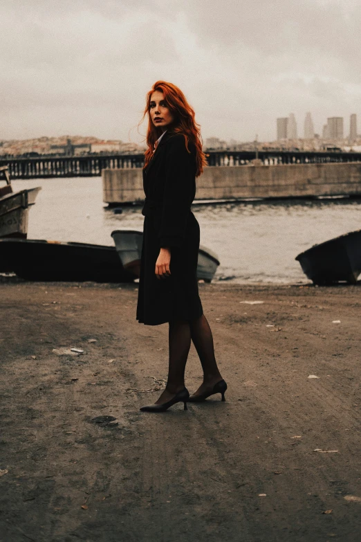 an attractive woman walking across a lot next to the ocean