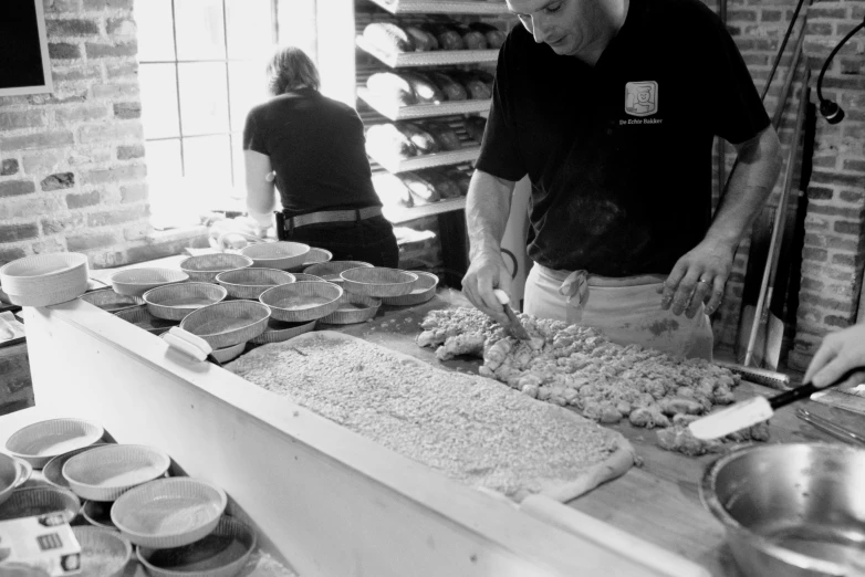 two people in a bakery preparing food for customers