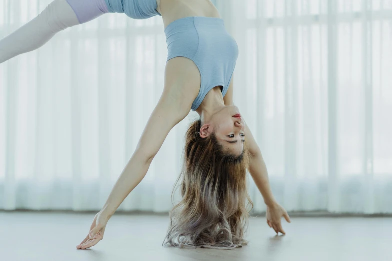 a girl doing a handstand in a room