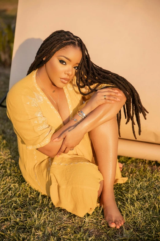 an african american woman sitting on the grass