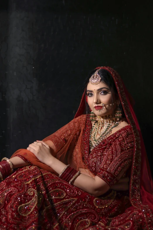 a woman wearing a red dress and jewelry poses for a po