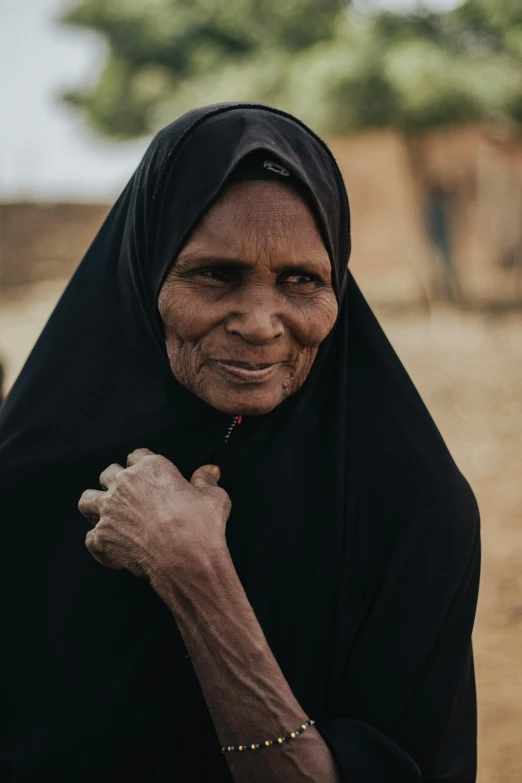 a woman in a black blanket posing for the camera