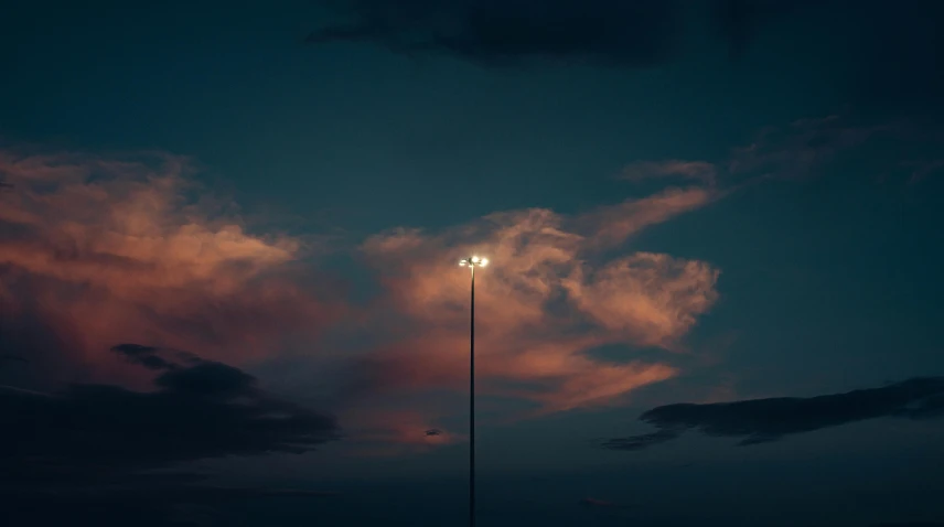 a large street light under clouds at night