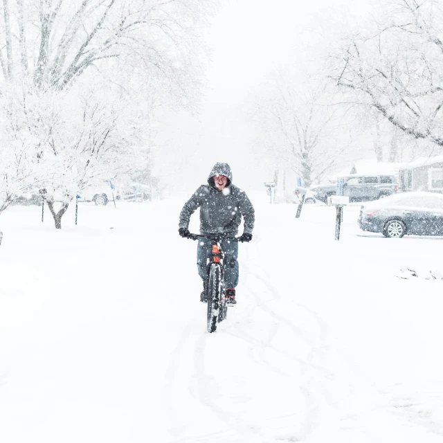 man on his bicycle moving through a snow storm