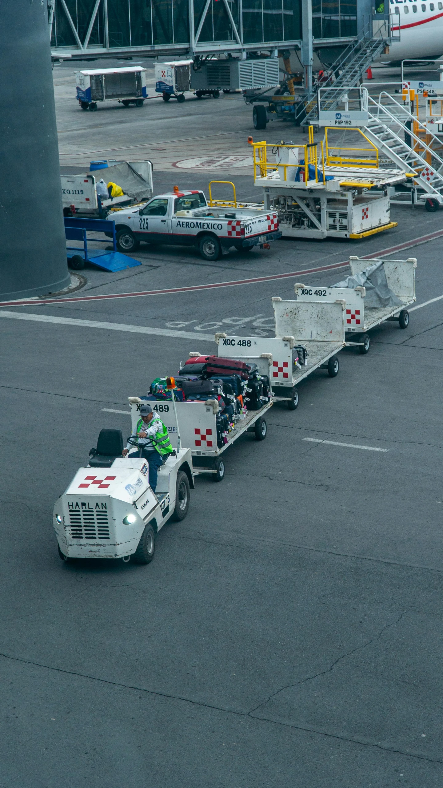 semi truck hauling a white utility vehicle on a paved tarmac