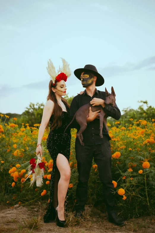 a man and woman posing for the camera with a cat