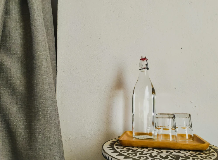 a bottle of alcohol next to some glasses on a table