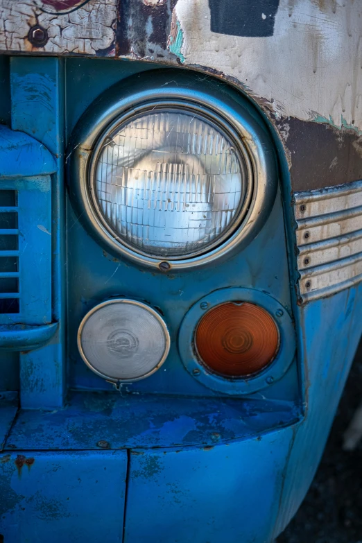 an old, dirty blue car with graffiti on it