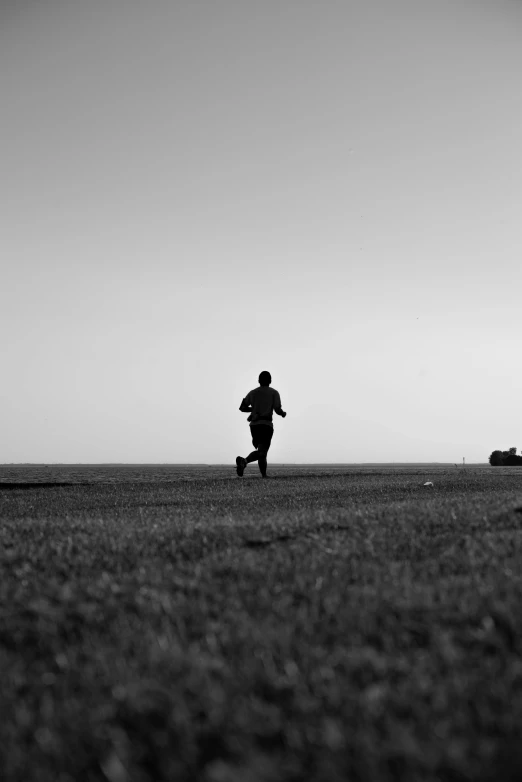 black and white image of man running across field