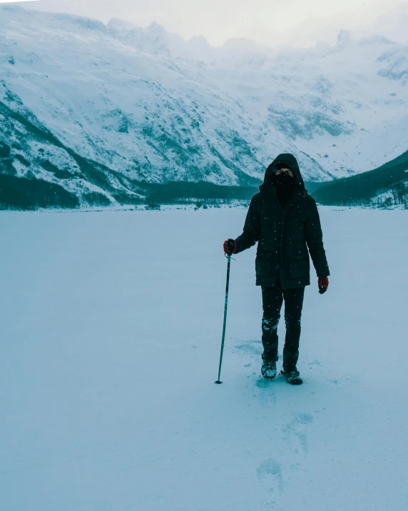 a man with skis standing in the snow