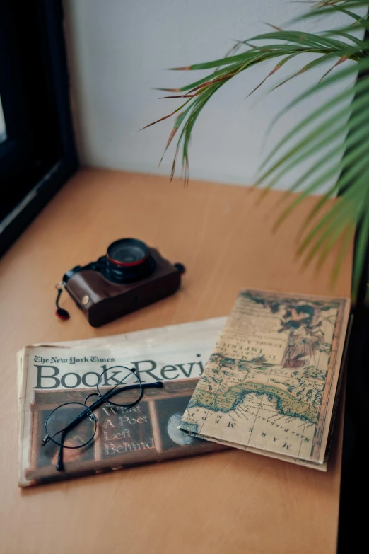 an old book and camera on a table