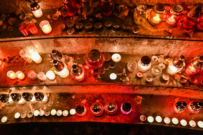 the overhead view shows several rows of lit candles on a wall