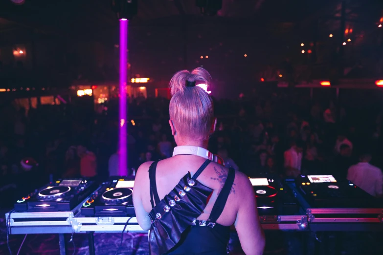 a woman dj mixing music in front of a crowd