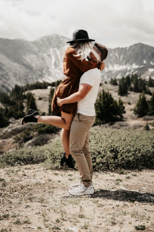 two young people are posing for a po together in the mountains