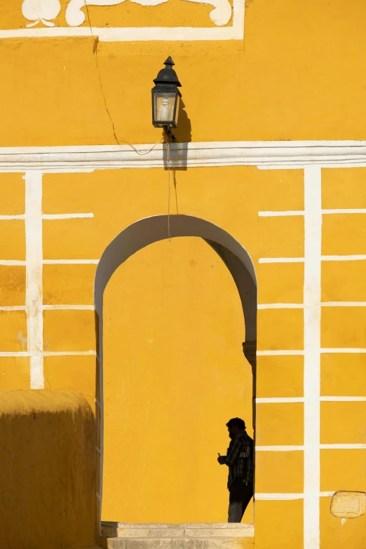 there is a person that is standing next to an arch