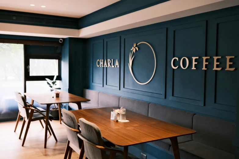 a restaurant with large walls, blue booths and wood tables