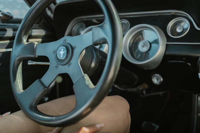 the driver's hands on the steering wheel are pointing towards the dashboard