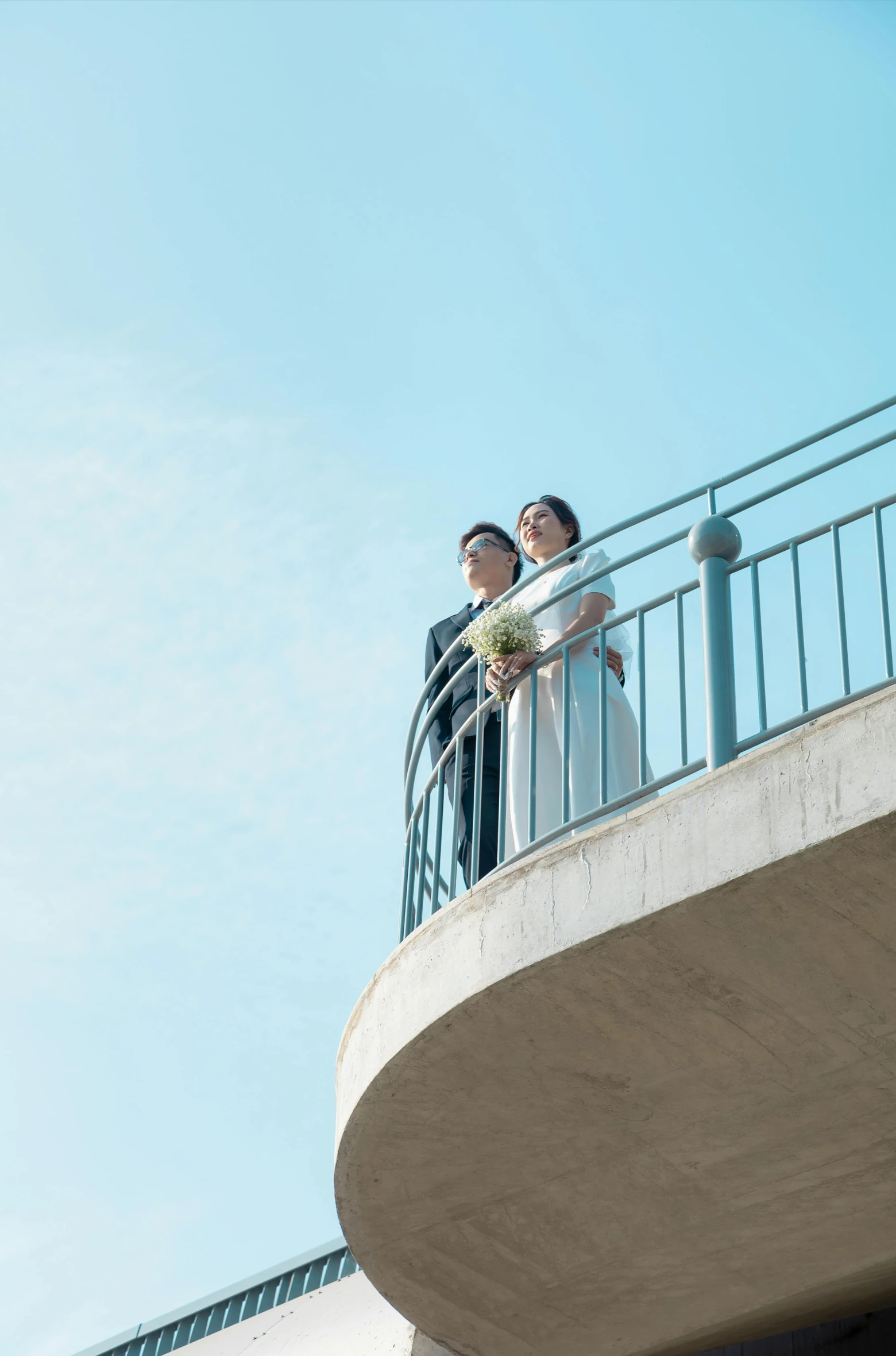 a bride and groom are overlooking a balcony