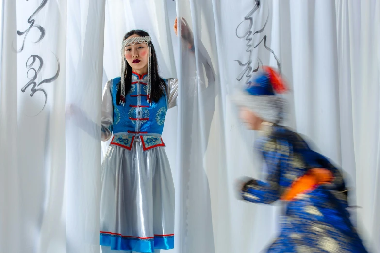 a woman dressed in traditional russian dress speaking to a man standing behind her