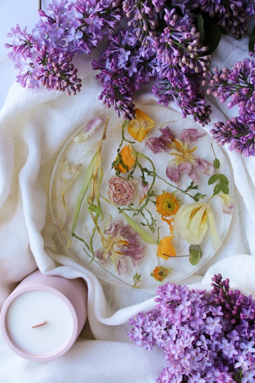 purple flowers in a clear bowl on white paper