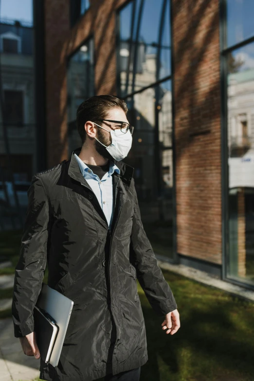 a man in a suit walking down the street wearing a mask