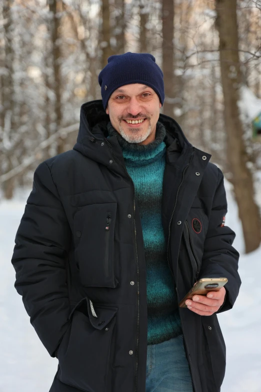 a man in winter coat standing outside on the snow