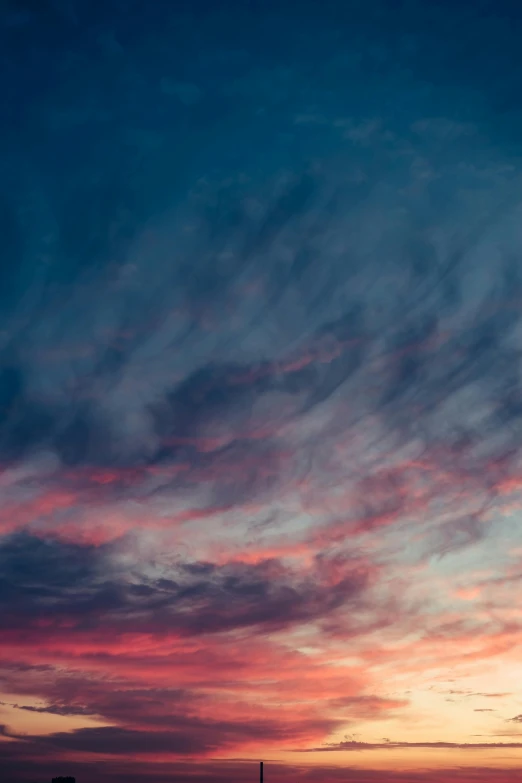 a colorful sky is over a tall structure in the distance