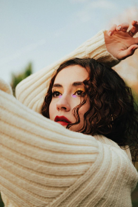 a woman with curly hair and blue eyes posing for a portrait