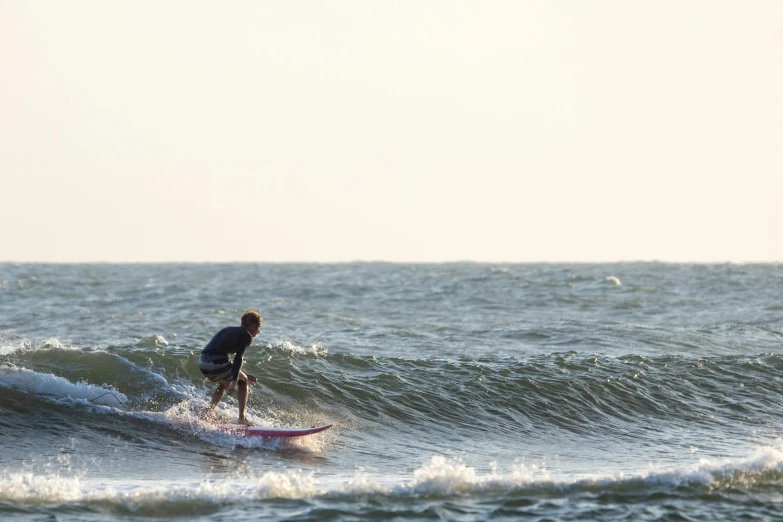 man surfing on a large wave near the shore