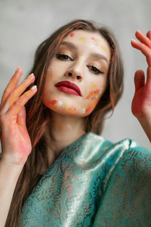 the woman with the orange paint painted on her face is posing