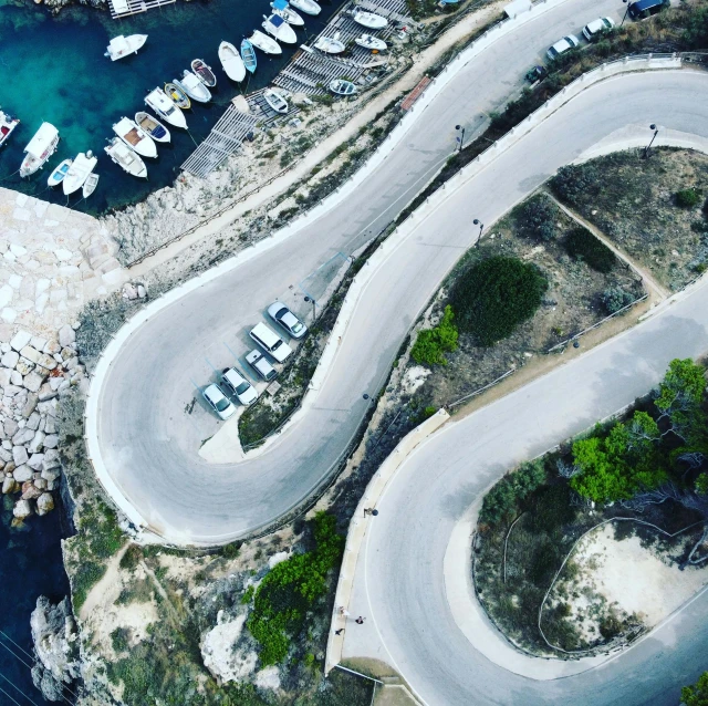 an aerial view of a road winding towards the water