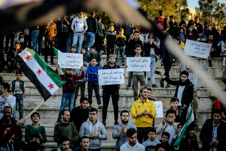 people are holding signs in front of a group of steps