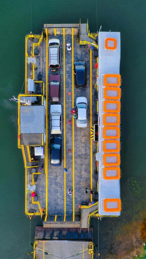 an overhead view of a ferry dock with cars parked in it