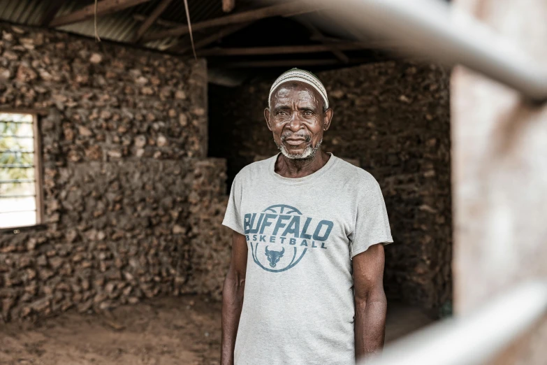 a black man standing in front of a building with a fence