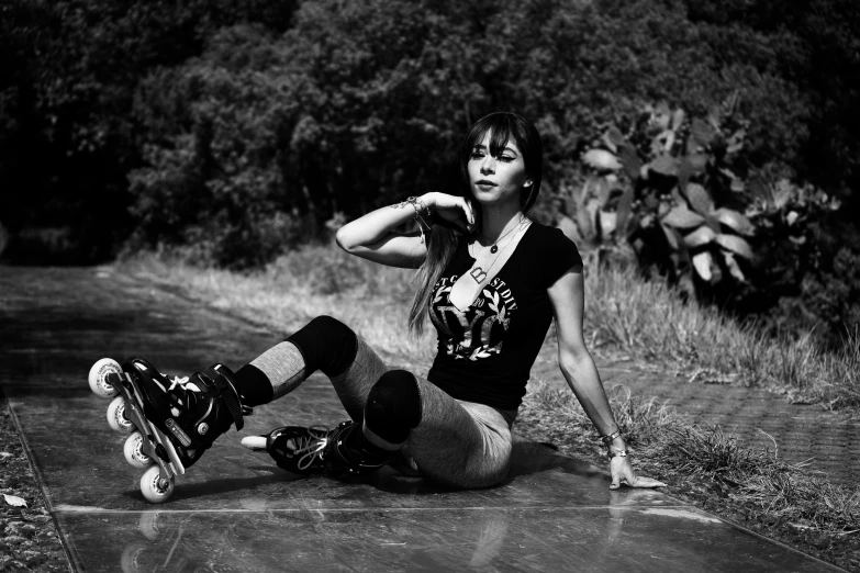 girl sitting on the ground with her skateboard in tow