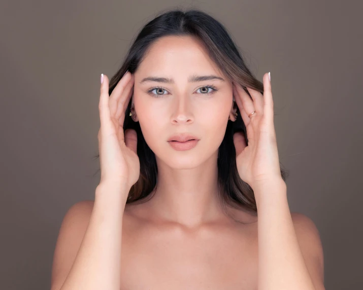 a woman holds her hands near her ears